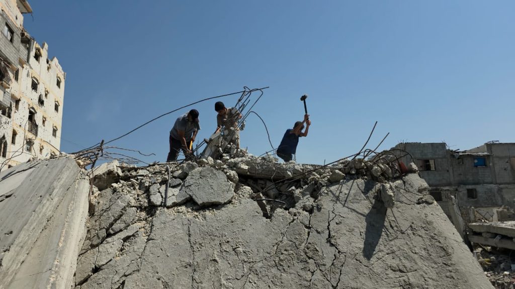 Khalil Abu Awda and his sons, Abdul Rahman, 14, and Muhammad, 16, work together to clear the rubble of their destroyed home so they can move from the al-Mawasi displacement camp in Khan Younis to their land. (Photo: Muhammad Eslayeh)