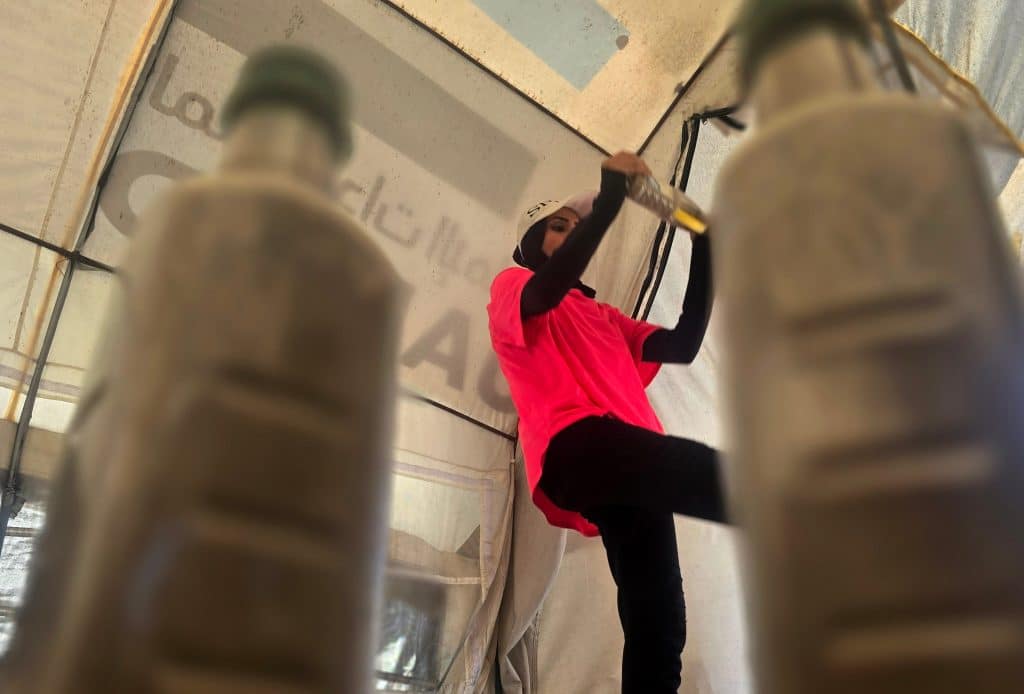 Palestinian fitness trainer Iman al-Mughir uses empty food cans and other waste items as part of her makeshift gym in Mawasi, Khan Younis, August 11, 2026. (Photo: Tariq Mohammad/APA Images)