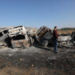 A Palestinian man inspects burnt scrap cars after an attack by Israeli settlers in the town of Huwwara in the Israeli-occupied West Bank, November 21, 2025. (Photo: Mohammed Nasser/APA Images)