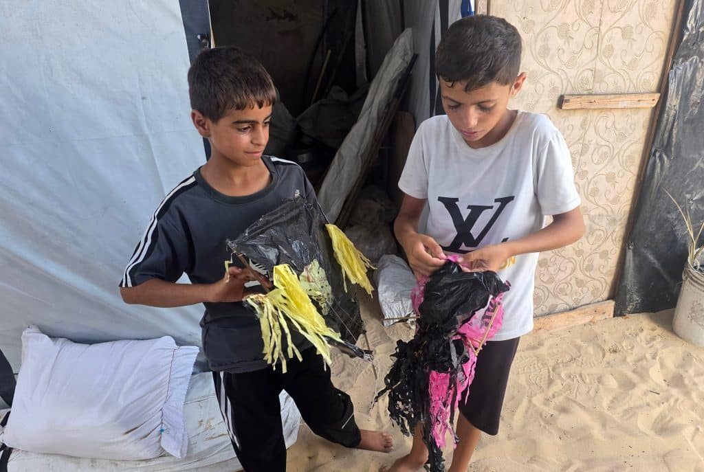 Children in Gaza fashion kites out of scrap material in the al-Mawasi area of Khan Younis, southern Gaza Strip, August 27, 2026. (Photo: Tariq Mohammad/APA Images)