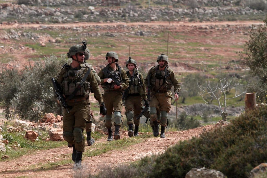 Israeli forces prevent Palestinians from planting olive trees on their land on Palestinian Land Day in the village of Qusra, March 30, 2022. (Photo: APA Images)