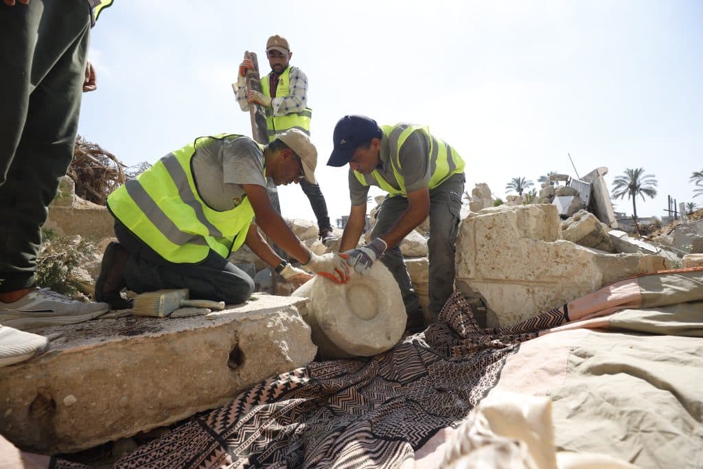 Members of the Heritage Guardians volunteer team, affiliated with the Mayasem Association for Culture and the Arts, examine and document historical artifacts recovered from beneath the rubble in Gaza, Khan Younis, June, 2026.(Photo: Yousef Abadla)