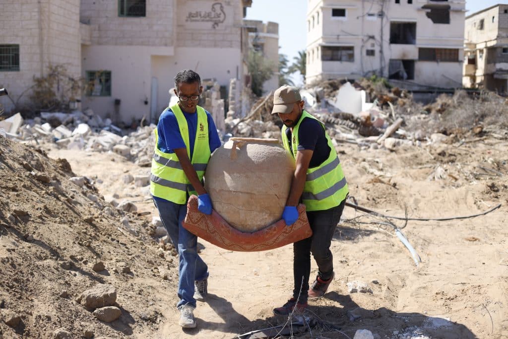 Members of the Heritage Guardians volunteer team, affiliated with the Mayasem Association for Culture and the Arts, examine and document historical artifacts recovered from beneath the rubble in Gaza, Khan Younis, June, 2026.(Photo: Yousef Abadla)