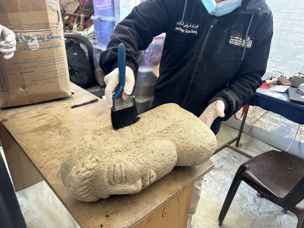 Members of the Heritage Guardians volunteer team, affiliated with the Mayasem Association for Culture and the Arts, examine and document historical artifacts recovered from beneath the rubble in Gaza, Khan Younis, June, 2026.(Photo: Yousef Abadla)
