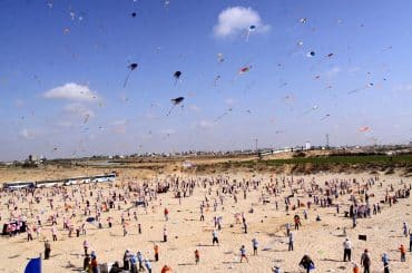 Palestinian children fly kites along the beach during a U.N.-run summer camp in Gaza City on July 29, 2010. (Photo: Mohammed Asad/APA Images)
