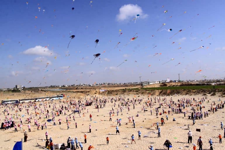 Palestinian children fly kites along the beach during a U.N.-run summer camp in Gaza City on July 29, 2010. (Photo: Mohammed Asad/APA Images)