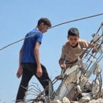 Abdulrahman and his brother go about demolishing their home and clearing its rubble. (Photo: Muhammad Eslayeh)