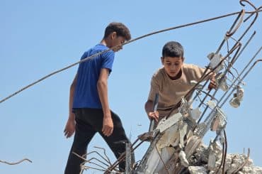 Abdulrahman and his brother go about demolishing their home and clearing its rubble. (Photo: Muhammad Eslayeh)