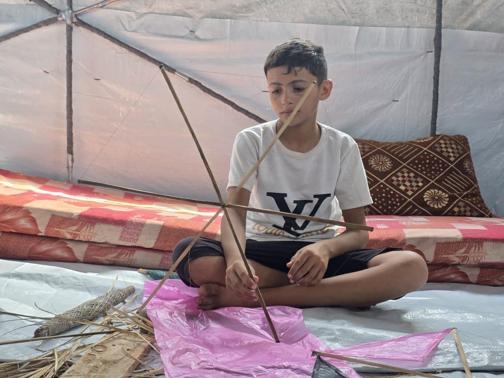 Children in Gaza fashion kites out of scrap material, August 2026. (Photo: Muhammad Eslayeh)