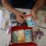 Palestinians receive cash aid from the United Nations in Deir al-Balah, central Gaza, October 14, 2021. (Photo: Ashraf Amra/APA Images)
