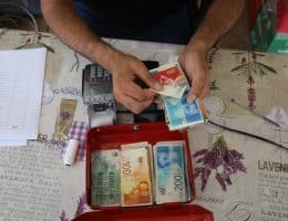 Palestinians receive cash aid from the United Nations in Deir al-Balah, central Gaza, October 14, 2021. (Photo: Ashraf Amra/APA Images)