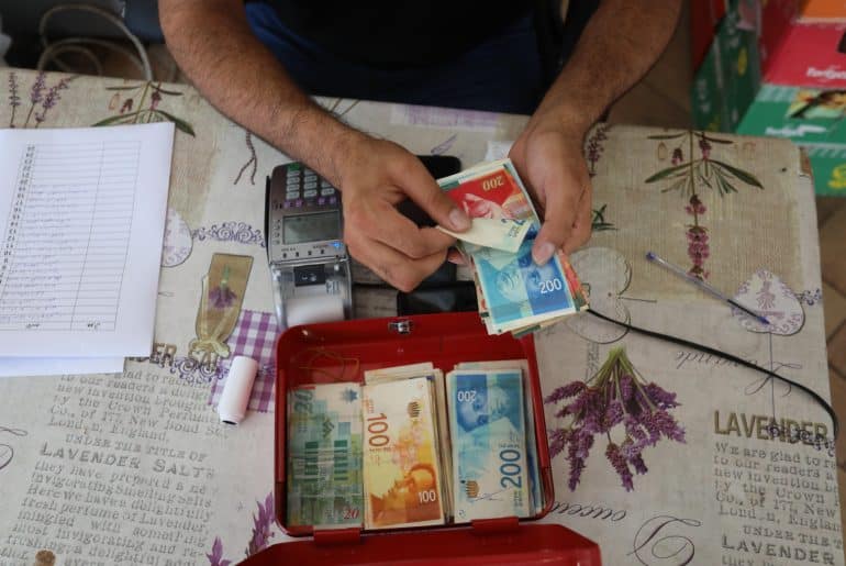 Palestinians receive cash aid from the United Nations in Deir al-Balah, central Gaza, October 14, 2021. (Photo: Ashraf Amra/APA Images)