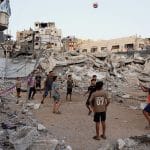 Children play volleyball on a makeshift court set up amid the rubble in Gaza City, September 16, 2026. (Photo: Bilal Osama/APA Images)