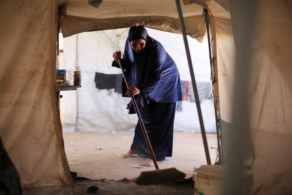 A Palestinian mother bathes her child inside a camp for displaced people in the al-Zawaida area of the central Gaza Strip, on June 17, 2026. Thousands of displaced families continue to endure harsh humanitarian conditions and extreme summer temperatures while living in tents that lack basic services and essential living conditions. (Hassan Jedi / apaimages)