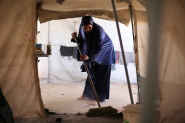 A Palestinian mother bathes her child inside a camp for displaced people in the al-Zawaida area of the central Gaza Strip, on June 17, 2026. Thousands of displaced families continue to endure harsh humanitarian conditions and extreme summer temperatures while living in tents that lack basic services and essential living conditions. (Hassan Jedi / apaimages)