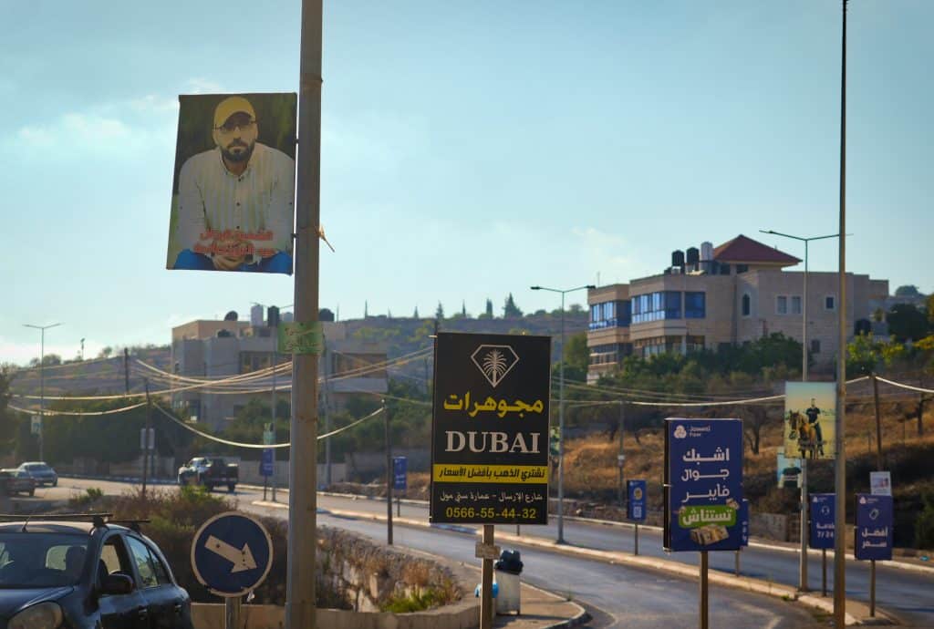 Portraits of Palestinians killed by the Israeli army or settlers along the road to the entrance of Deir Jarir. (Photo: Qassam Muaddi/Mondoweiss)