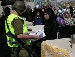Israeli soldiers checking IDs of Palestinian women as they pass security checks at Qalandia checkpoint on the outskirts of the West Bank city of Ramallah on August 13, 2010. (Photo: Wagdi Eshtayah/APA Images)